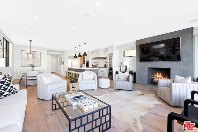 living room with light wood-type flooring and a fireplace