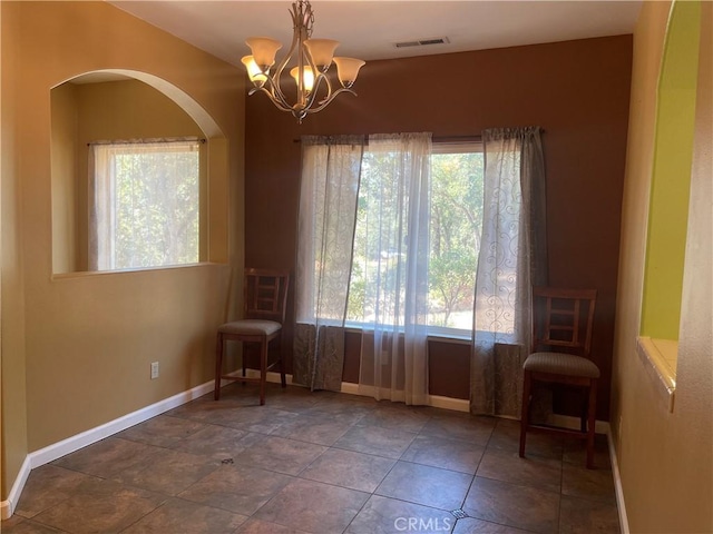 unfurnished room featuring a chandelier and tile patterned floors