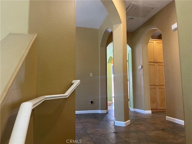 hall featuring dark tile patterned floors