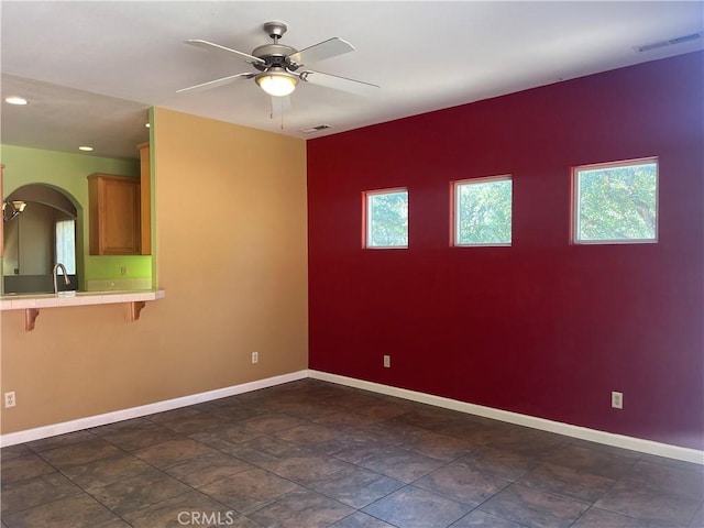 unfurnished room featuring ceiling fan and a healthy amount of sunlight