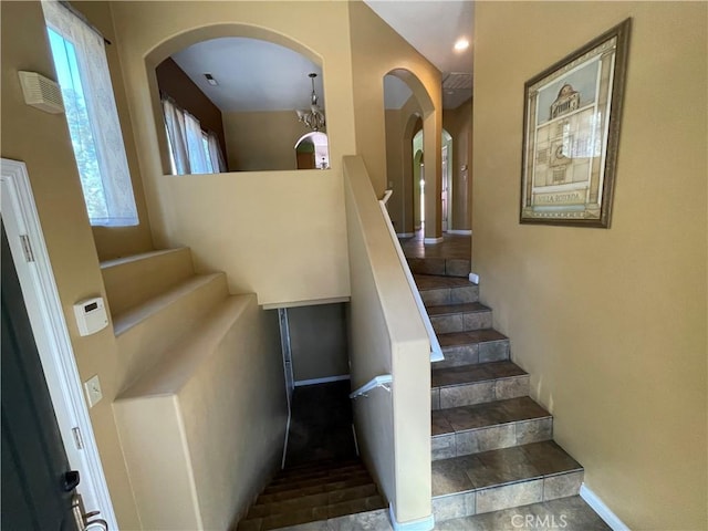 stairway featuring a chandelier