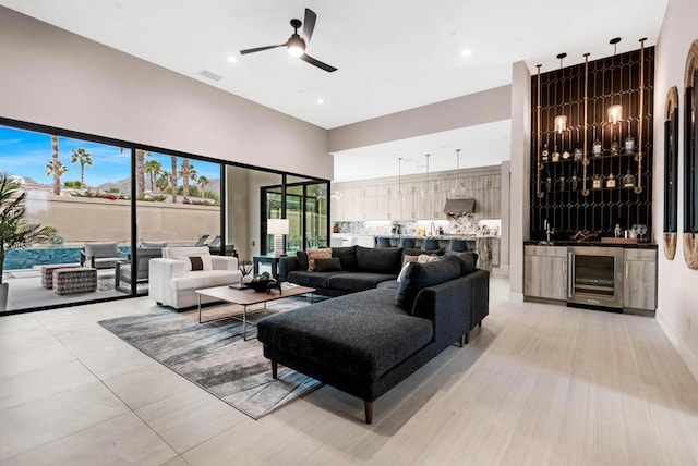 living room with ceiling fan, light tile patterned floors, bar, and wine cooler