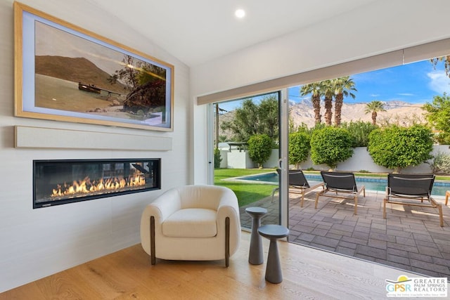 sitting room featuring a mountain view, hardwood / wood-style floors, and lofted ceiling