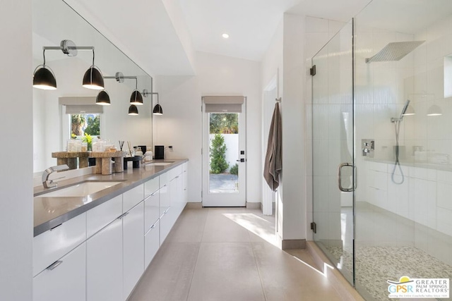 bathroom featuring a shower with door, vanity, plenty of natural light, and vaulted ceiling