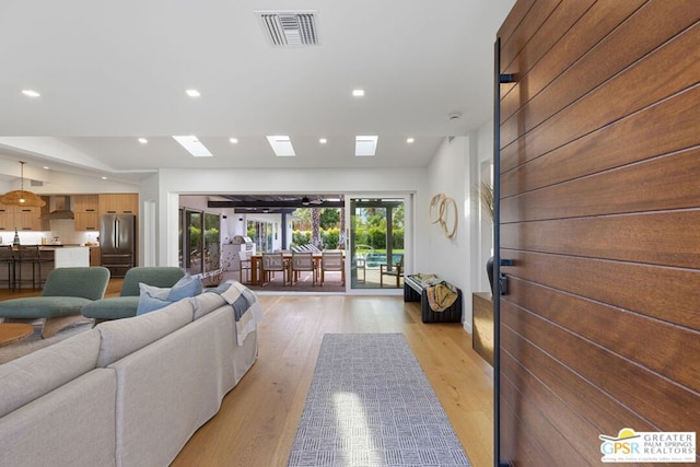 living room featuring a skylight and light wood-type flooring