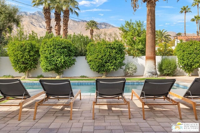 view of patio / terrace with a mountain view and a fenced in pool