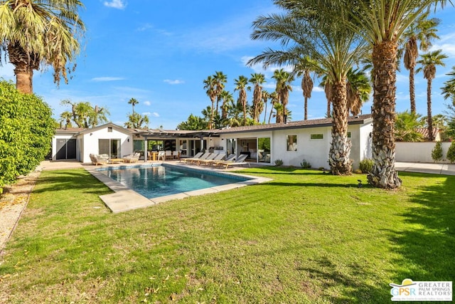 back of property with a lawn and a patio area