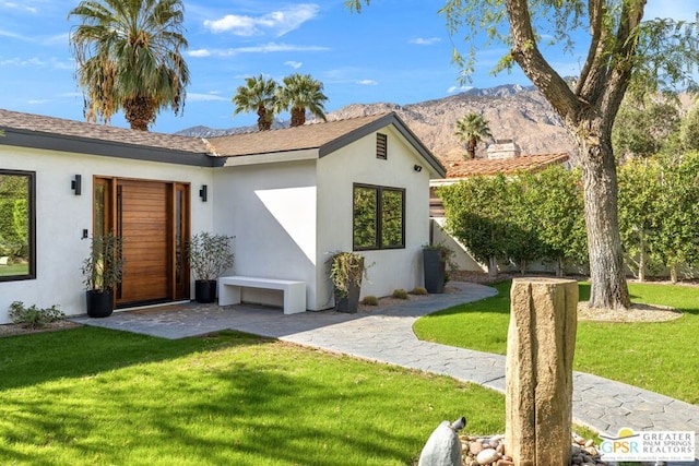 ranch-style house with a mountain view and a front lawn