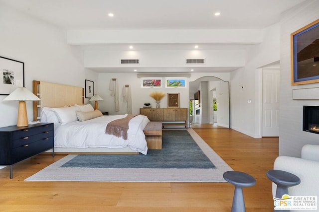 bedroom with hardwood / wood-style flooring and beamed ceiling