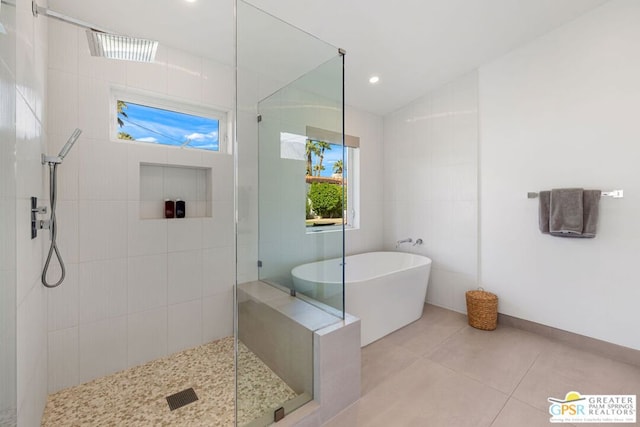 bathroom with tile patterned flooring, separate shower and tub, and tile walls