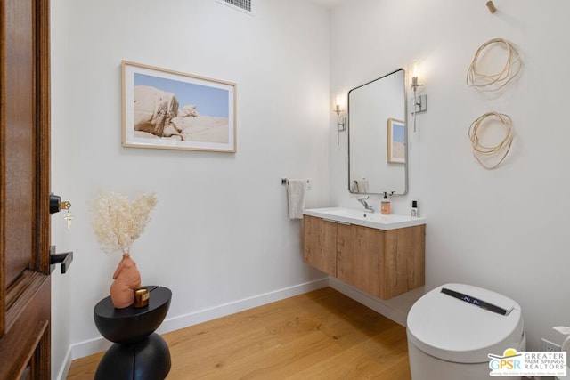 bathroom featuring vanity, hardwood / wood-style floors, and toilet