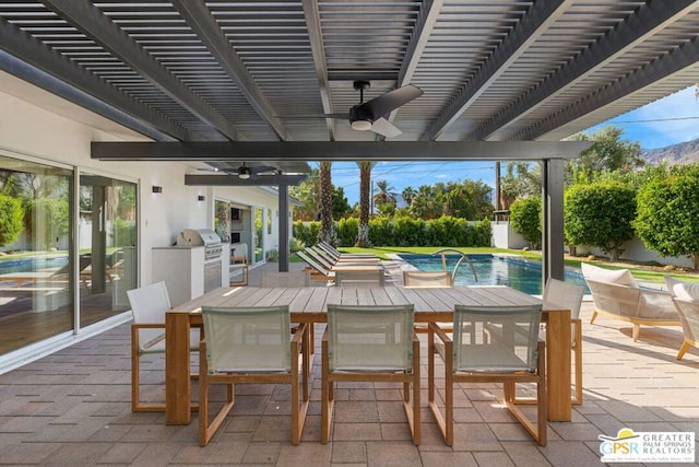 view of patio featuring a fenced in pool, a pergola, ceiling fan, and exterior kitchen