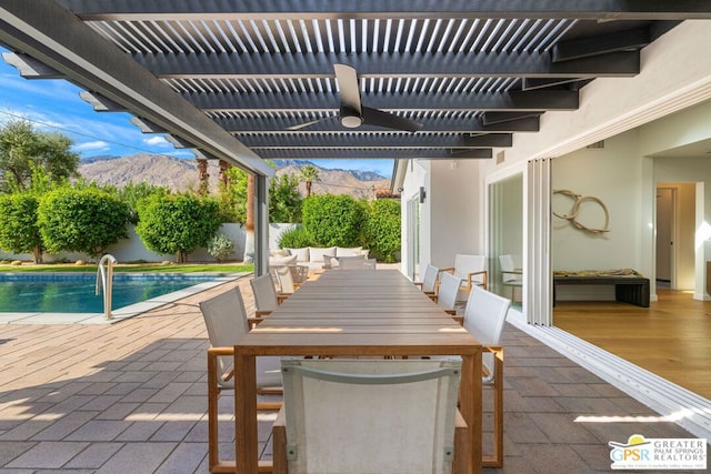 view of patio / terrace with a fenced in pool, a mountain view, and a pergola