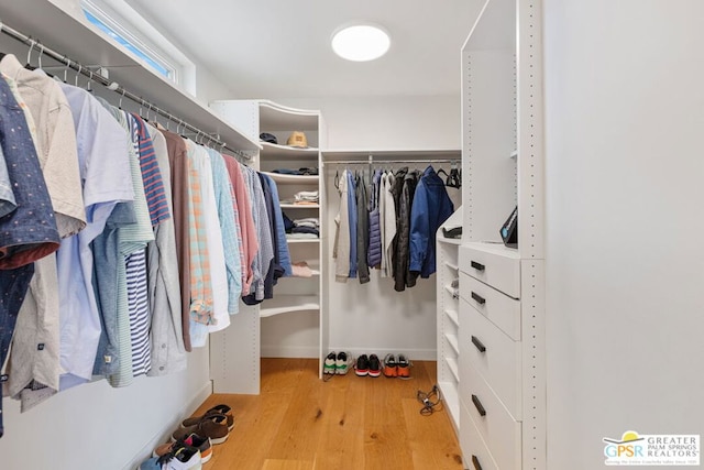 walk in closet with light hardwood / wood-style floors