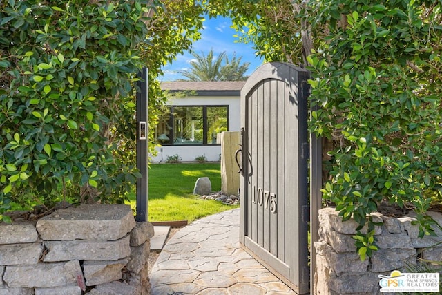 view of gate featuring a lawn