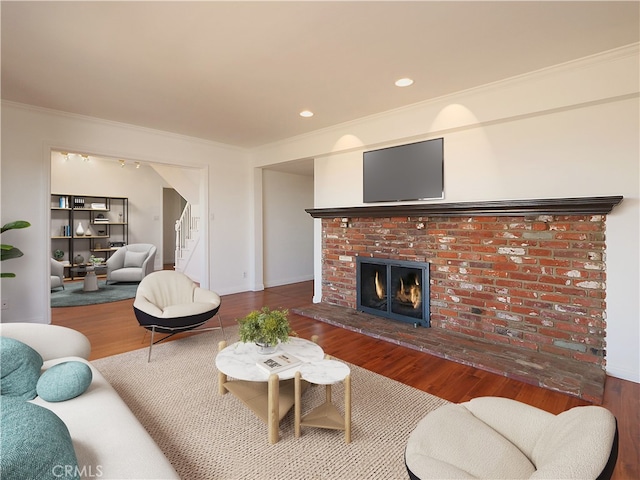 living room with a fireplace, hardwood / wood-style floors, and ornamental molding