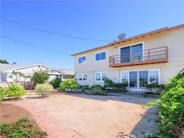 back of property featuring a balcony and a patio area