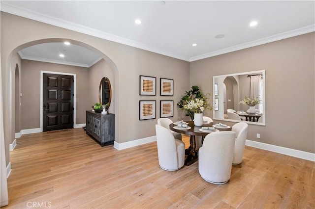 dining space featuring light wood-type flooring and ornamental molding