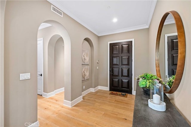 entryway featuring light wood-type flooring and ornamental molding