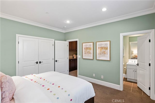 bedroom with ensuite bathroom, a closet, crown molding, and dark colored carpet