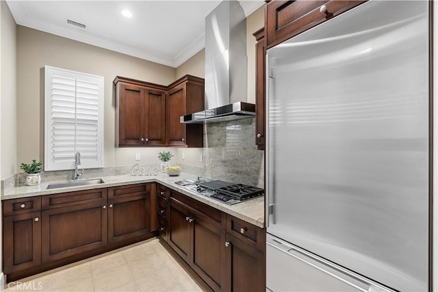 kitchen featuring sink, wall chimney exhaust hood, light stone counters, crown molding, and appliances with stainless steel finishes