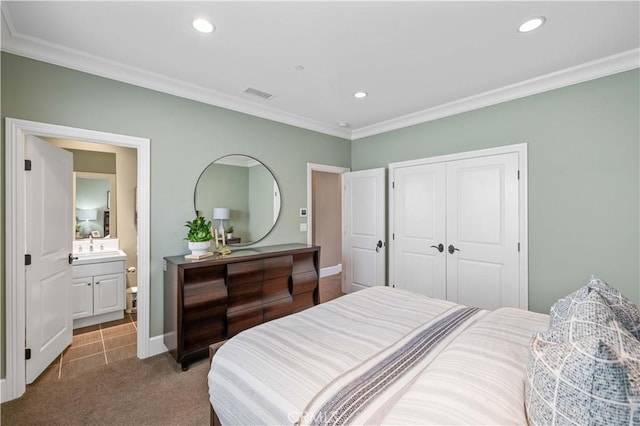 carpeted bedroom with ensuite bath, sink, crown molding, and a closet