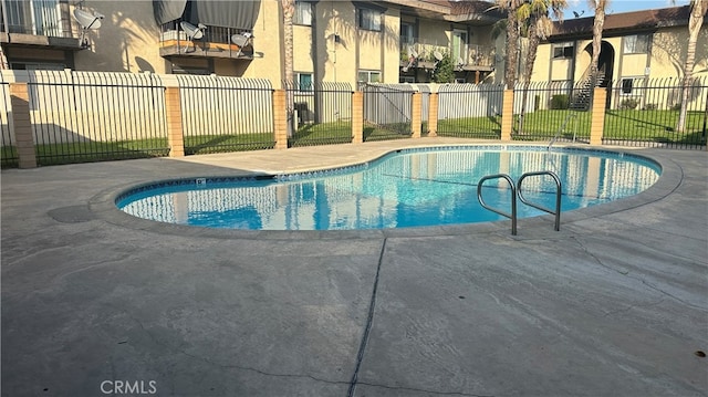 view of pool with a patio area and a lawn