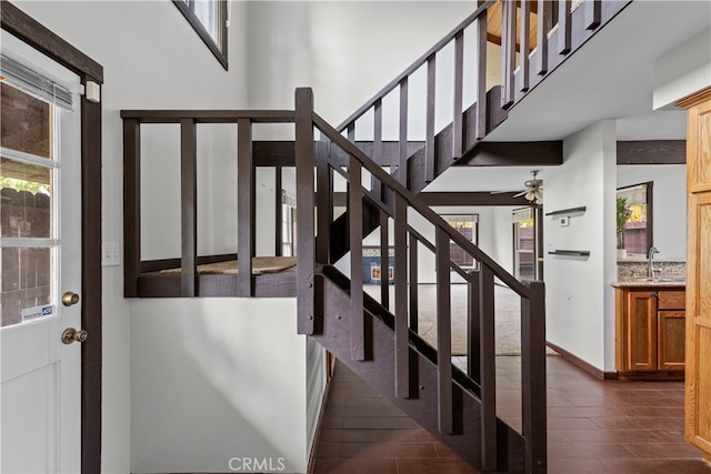 staircase with ceiling fan and wood-type flooring