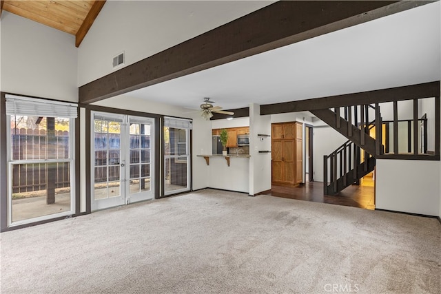 unfurnished living room featuring carpet floors, lofted ceiling with beams, plenty of natural light, and ceiling fan