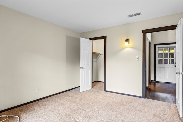 unfurnished bedroom featuring a spacious closet, carpet floors, and a closet