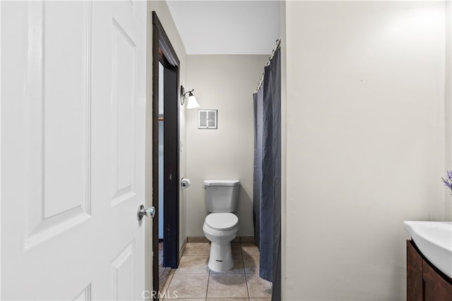 bathroom with toilet, vanity, and tile patterned floors