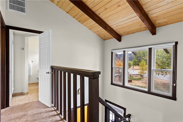 hallway featuring vaulted ceiling with beams, light tile patterned flooring, and wooden ceiling