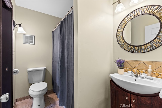 bathroom with toilet, vanity, and tile patterned floors