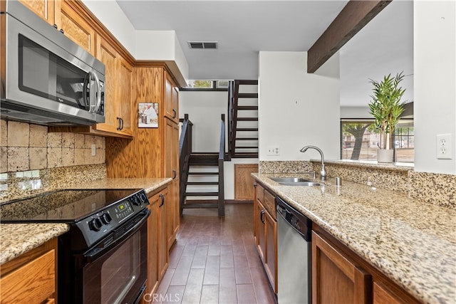 kitchen with decorative backsplash, dark wood-type flooring, stainless steel appliances, sink, and light stone counters