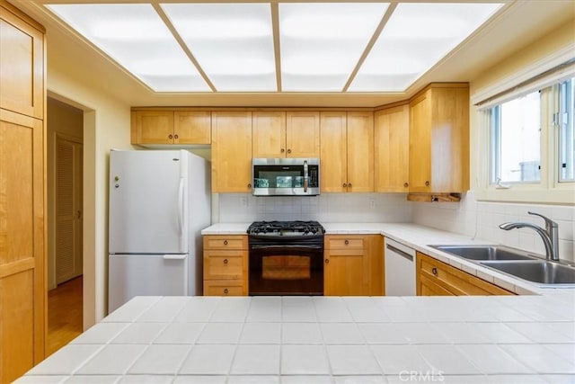 kitchen with white appliances, tasteful backsplash, tile counters, and sink