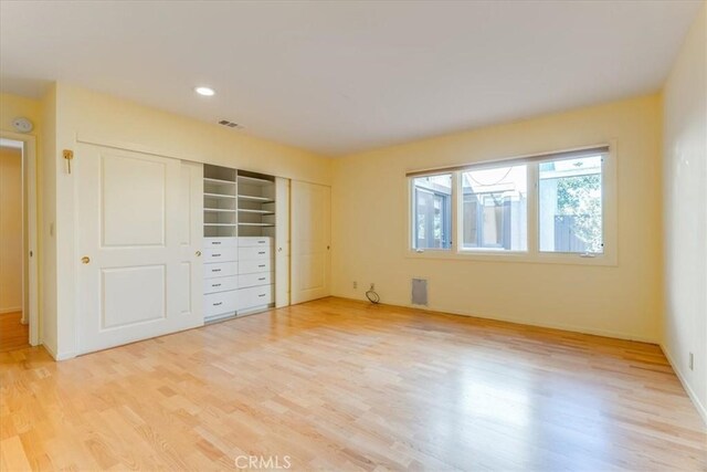 unfurnished bedroom featuring a closet and light wood-type flooring