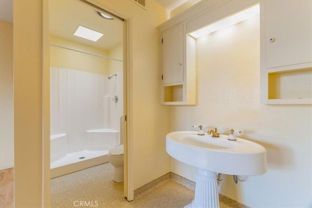 bathroom with a shower and toilet