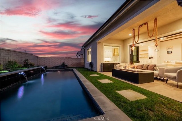 pool at dusk with pool water feature, an outdoor hangout area, and a patio