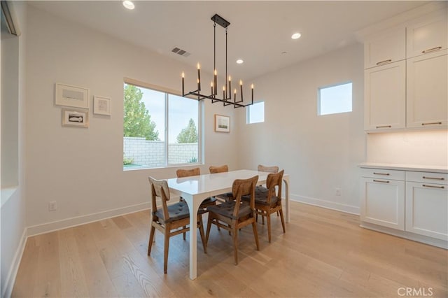 dining space with a chandelier and light wood-type flooring