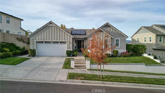 view of front facade featuring a garage, a front yard, and solar panels