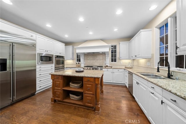 kitchen featuring white cabinets, built in appliances, and a kitchen island