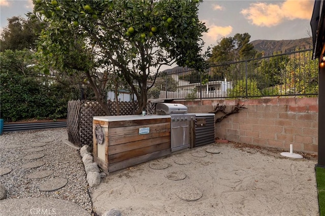 patio terrace at dusk with area for grilling and a mountain view