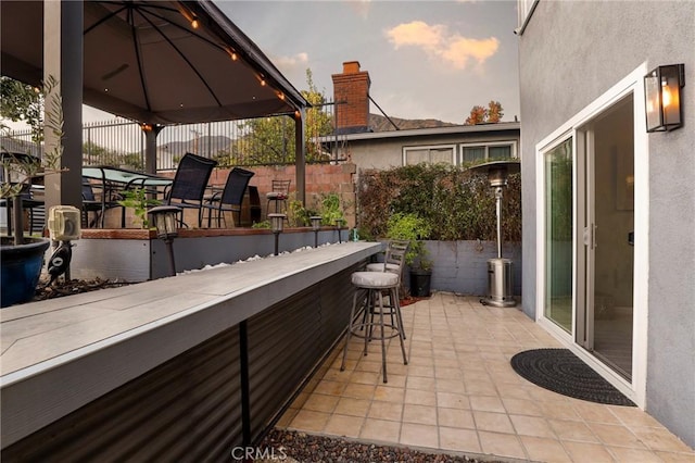 balcony at dusk with a bar and a patio area