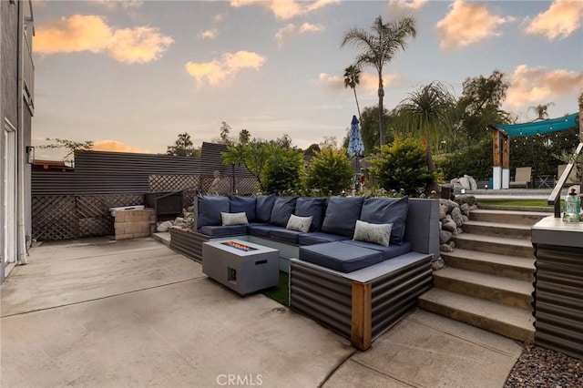 patio terrace at dusk with an outdoor living space with a fire pit