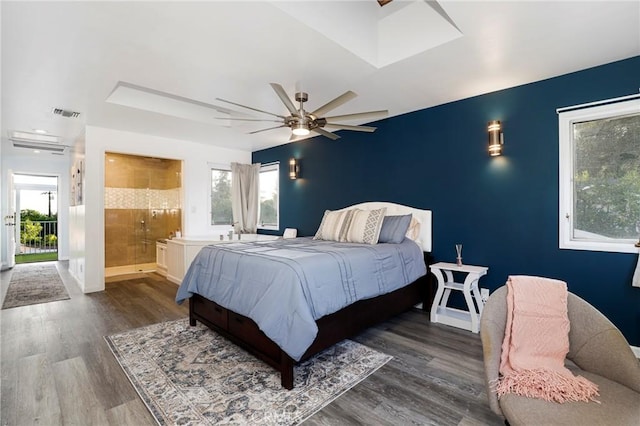 bedroom featuring ceiling fan, ensuite bath, and dark wood-type flooring