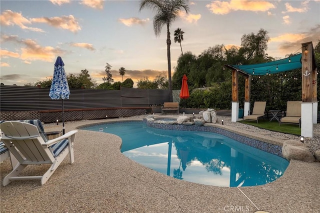 pool at dusk featuring a patio area