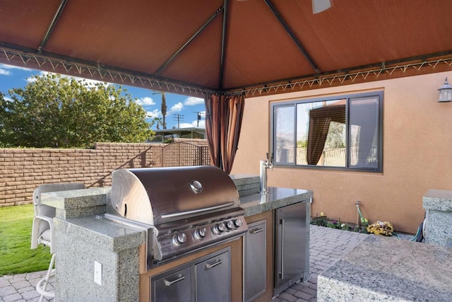 view of patio featuring a gazebo, an outdoor kitchen, and grilling area