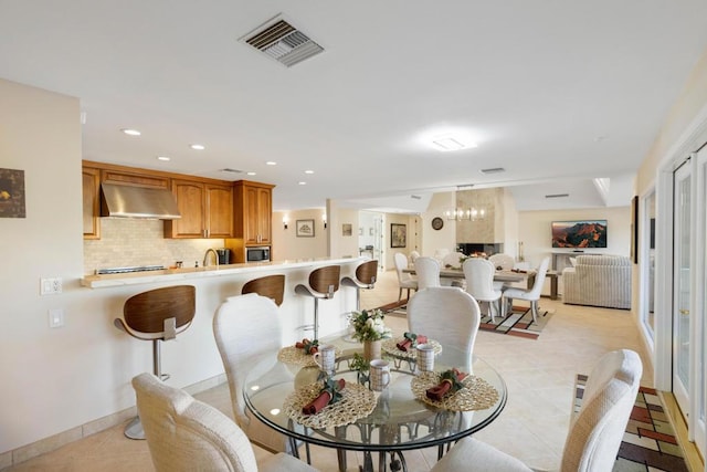 dining area with light tile patterned floors and an inviting chandelier