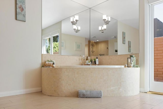 bathroom with decorative backsplash and a notable chandelier