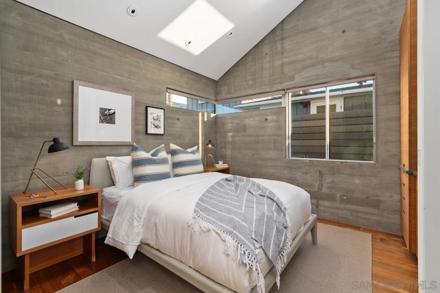 bedroom featuring wood-type flooring and high vaulted ceiling